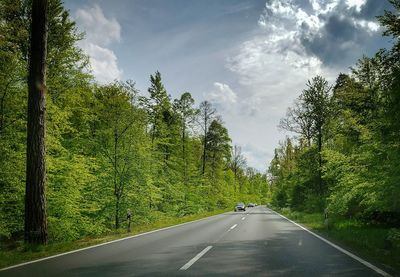 Road amidst trees against sky