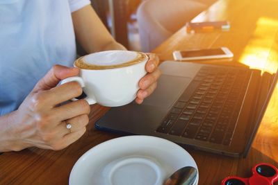 Midsection of coffee cup on table