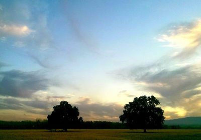 Scenic view of grassy field against cloudy sky