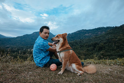 Young man with dog on field