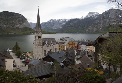 High angle view of townscape by lake and buildings against sky