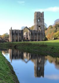 Fountains abbey in yorkshire full reflection on water.
