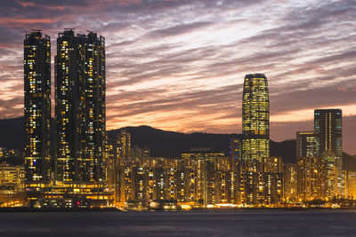 Illuminated modern buildings against sky at night