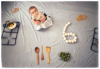 High angle view of baby lying on bed