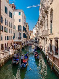 Boats in canal amidst buildings in city