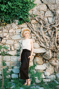 Portrait of young woman standing on rock