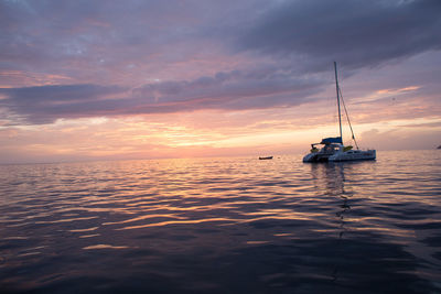 Boats in sea at sunset