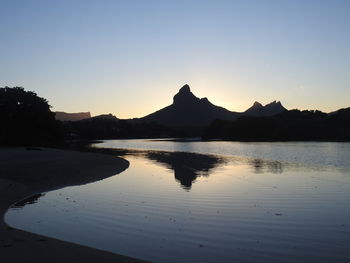 Scenic view of lake against clear sky during sunset