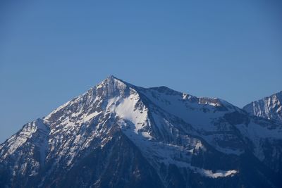 Scenic view of snowcapped mountains against clear blue sky