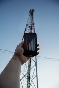 Low angle view of man photographing through smart phone