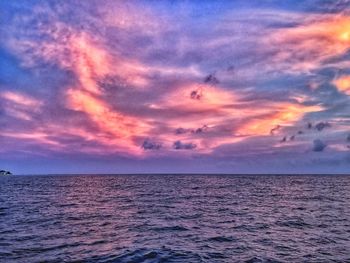 Scenic view of sea against dramatic sky during sunset