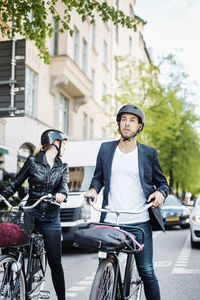 Business people with bicycles waiting on city street