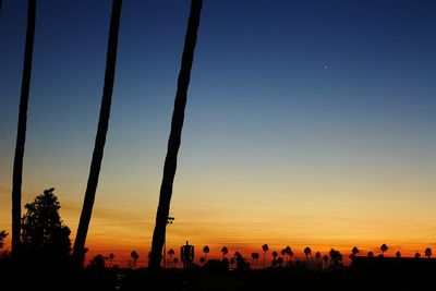 Silhouette city against clear sky during sunset