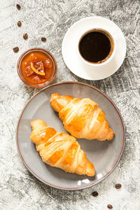 Breakfast with croissants. fresh crispy croissants and coffee on a light background, top view/