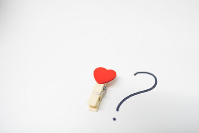 Close-up of red heart shape over white background