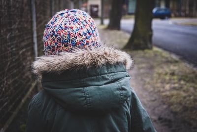 Rear view of person wearing knit hat on sidewalk