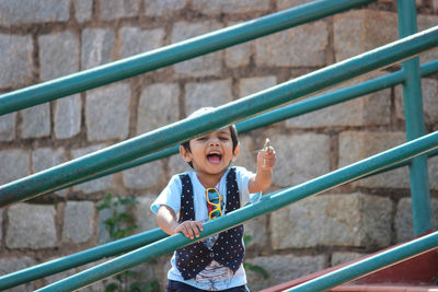 Portrait of boy standing on railing