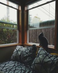 Low section of man resting on window at home