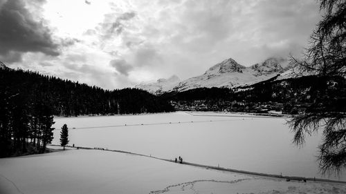 Scenic view of snow covered mountains against cloudy sky