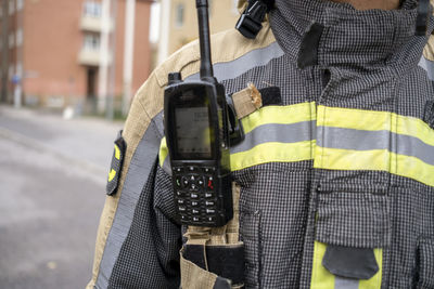Mid section of firefighter with walkie talkie