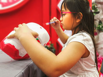 Close-up of cute girl painting craft product 