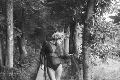 Woman standing on footpath in forest