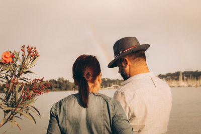 Rear view of couple kissing against sky