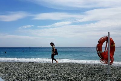 Boy on beach against sky