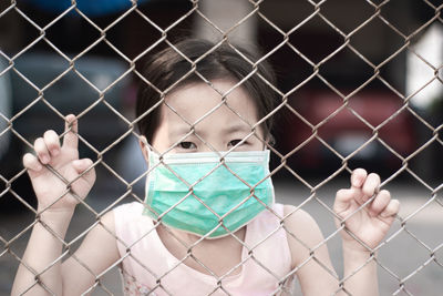 Portrait of person seen through chainlink fence