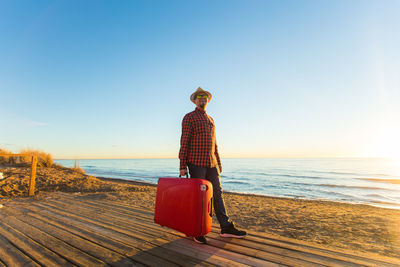 Woman on beach against clear sky