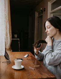Young woman using mobile phone while sitting at home