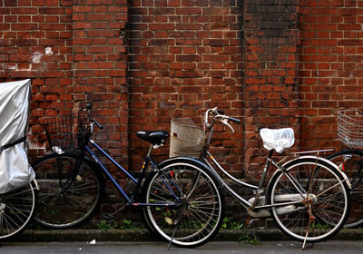 Bicycle parked against brick wall