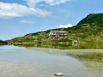 Scenic view of lake by buildings against sky