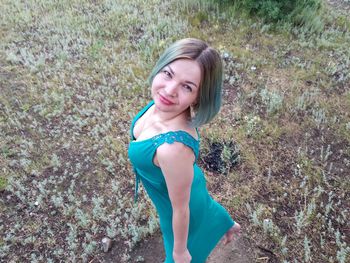 Portrait of beautiful woman standing on field