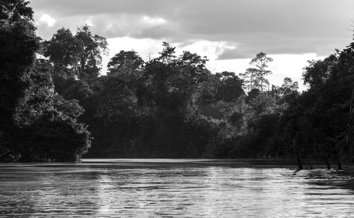 Scenic view of river against cloudy sky