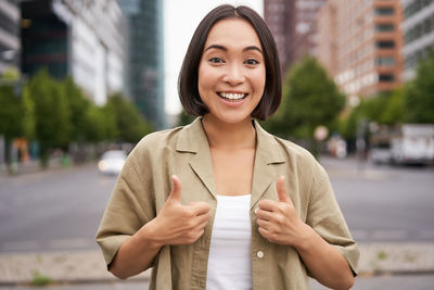 Portrait of young woman standing in city