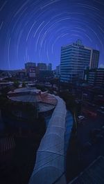 Digital composite image of illuminated buildings against clear sky at night