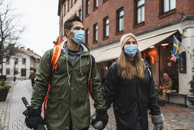 Female and male tourists exploring city during covid-19