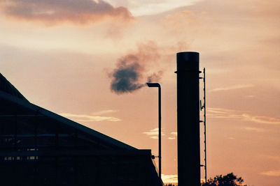 Low angle view of smoke emitting from factory against sky