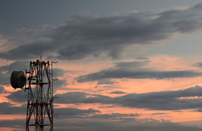 Low angle view of telephone pole against sky during sunset