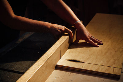 Low section of woman working on wood