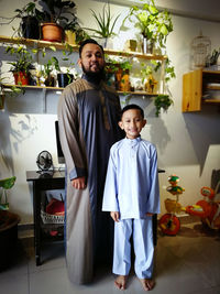 Full length portrait of man with son wearing kurta