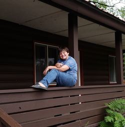 Portrait of smiling boy sitting at balcony 