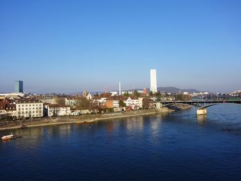 River in city against clear blue sky