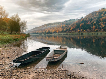 Incredible natural landscape with river, forest, boats. wooden boats on river bank under cloudy sky