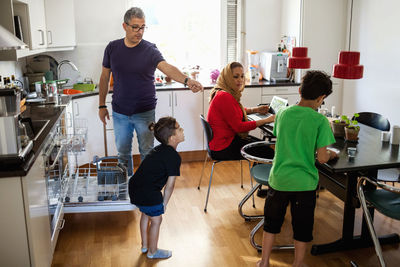 Family of four in brightly lit kitchen