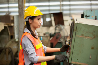 Portrait of young woman standing in factory