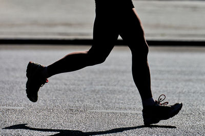 Low section of man running on street