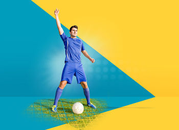 Soccer player with ball standing against colored background