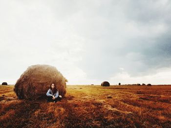 Hay bales on field against sky